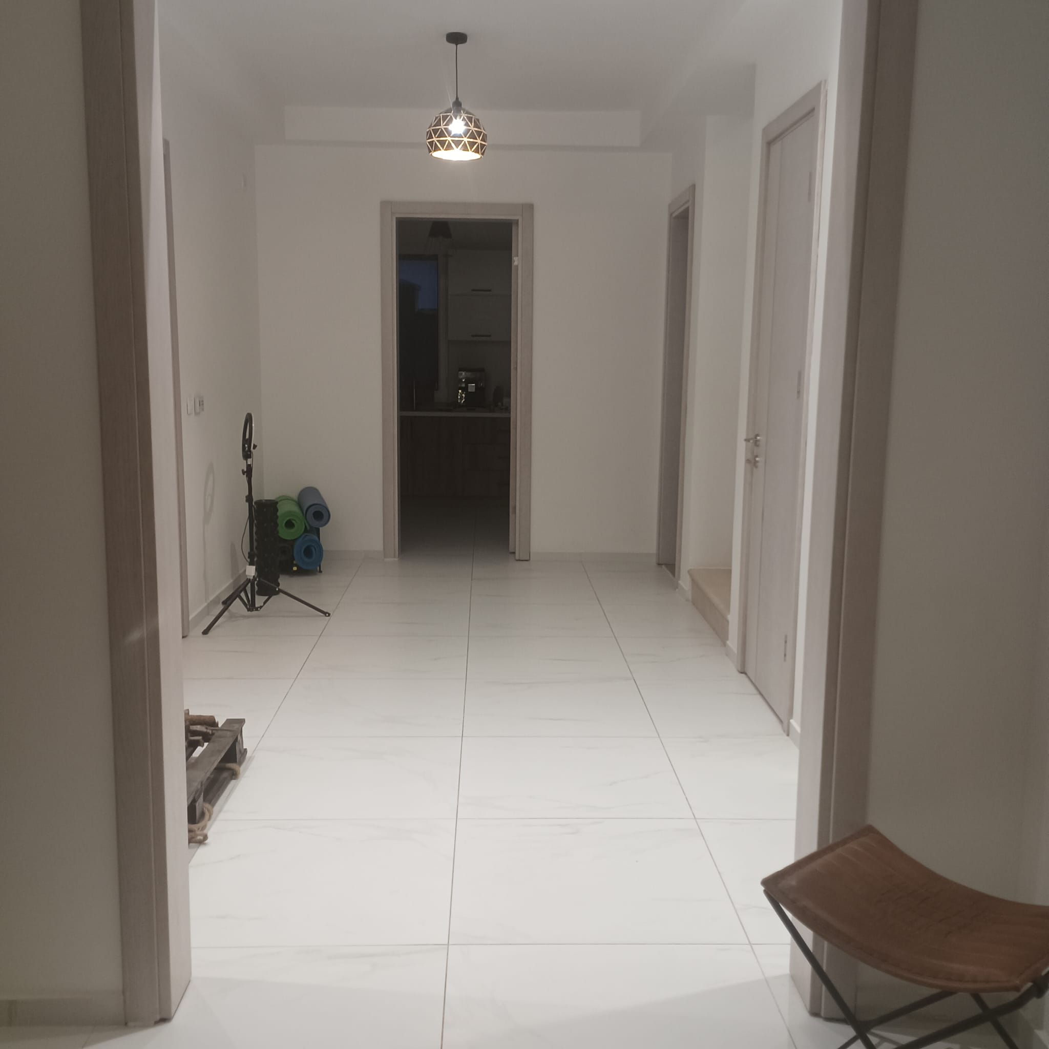 Modern hallway in Ulcinj property with white tiles, open layout, kitchen, and wellness space&mdash;exclusive on immobilien.ekosphere.me by ekosphere doo.
