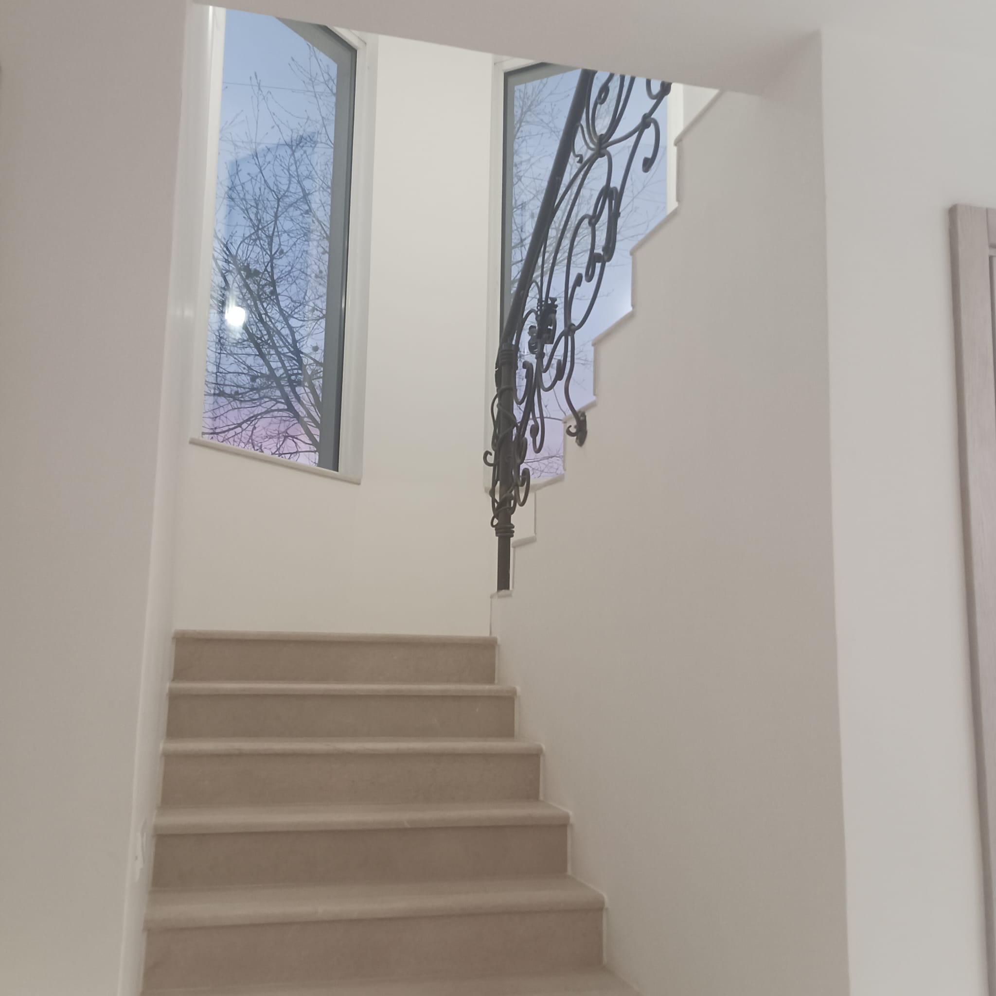 Elegant beige staircase with black metal railing, large windows, and Ulcinj views&mdash;exclusive investment at immobilien.ekosphere.me by ekosphere doo.