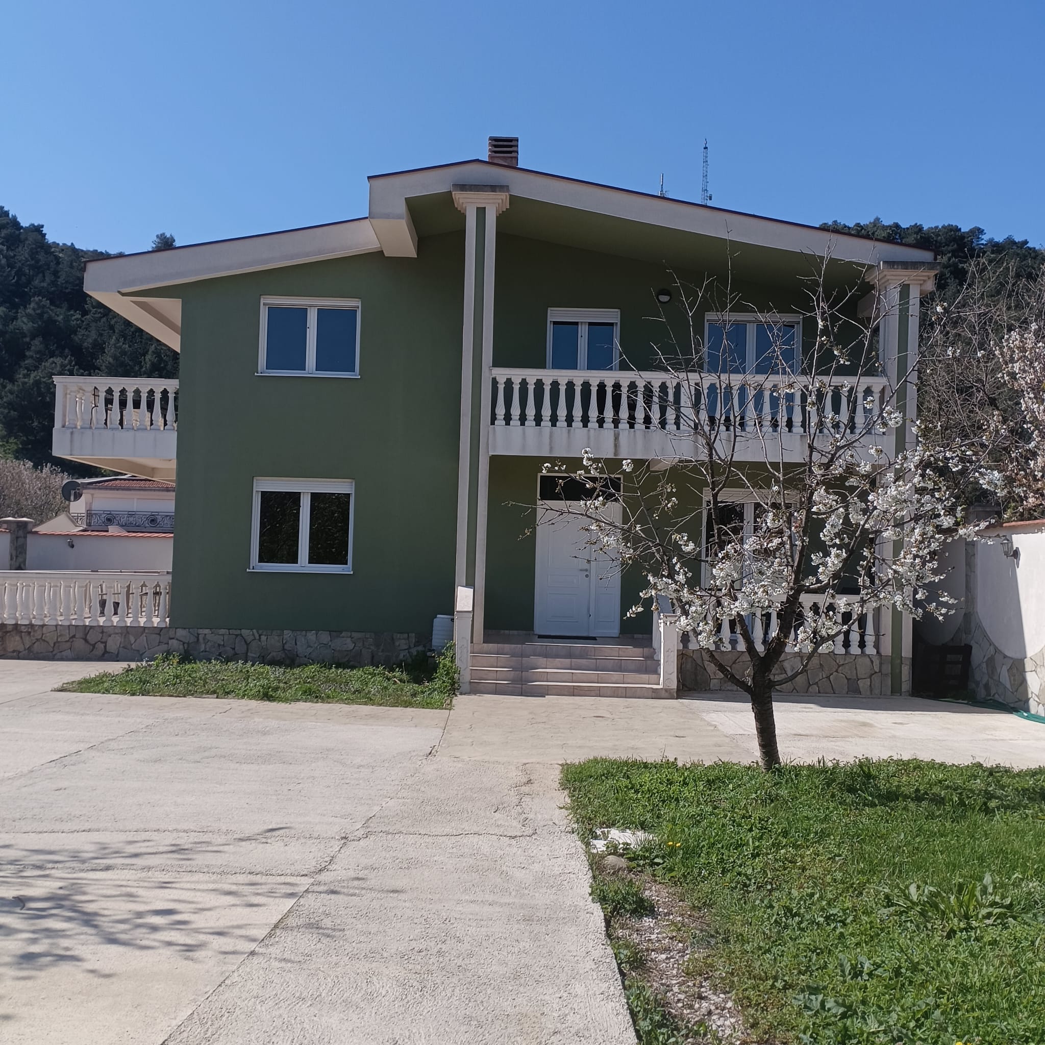 Charming two-story green home in Ulcinj, Montenegro with balcony, lush yard, and scenic views. Exclusive at immobilien.ekosphere.me by ekosphere doo.