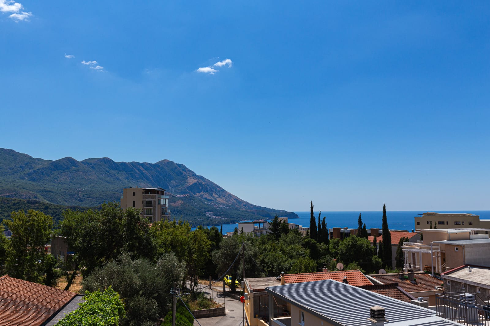 Stunning Ulcinj real estate: red-roofed homes, lush greenery, sea views, and mountains. Invest in Montenegro with ekosphere doo.