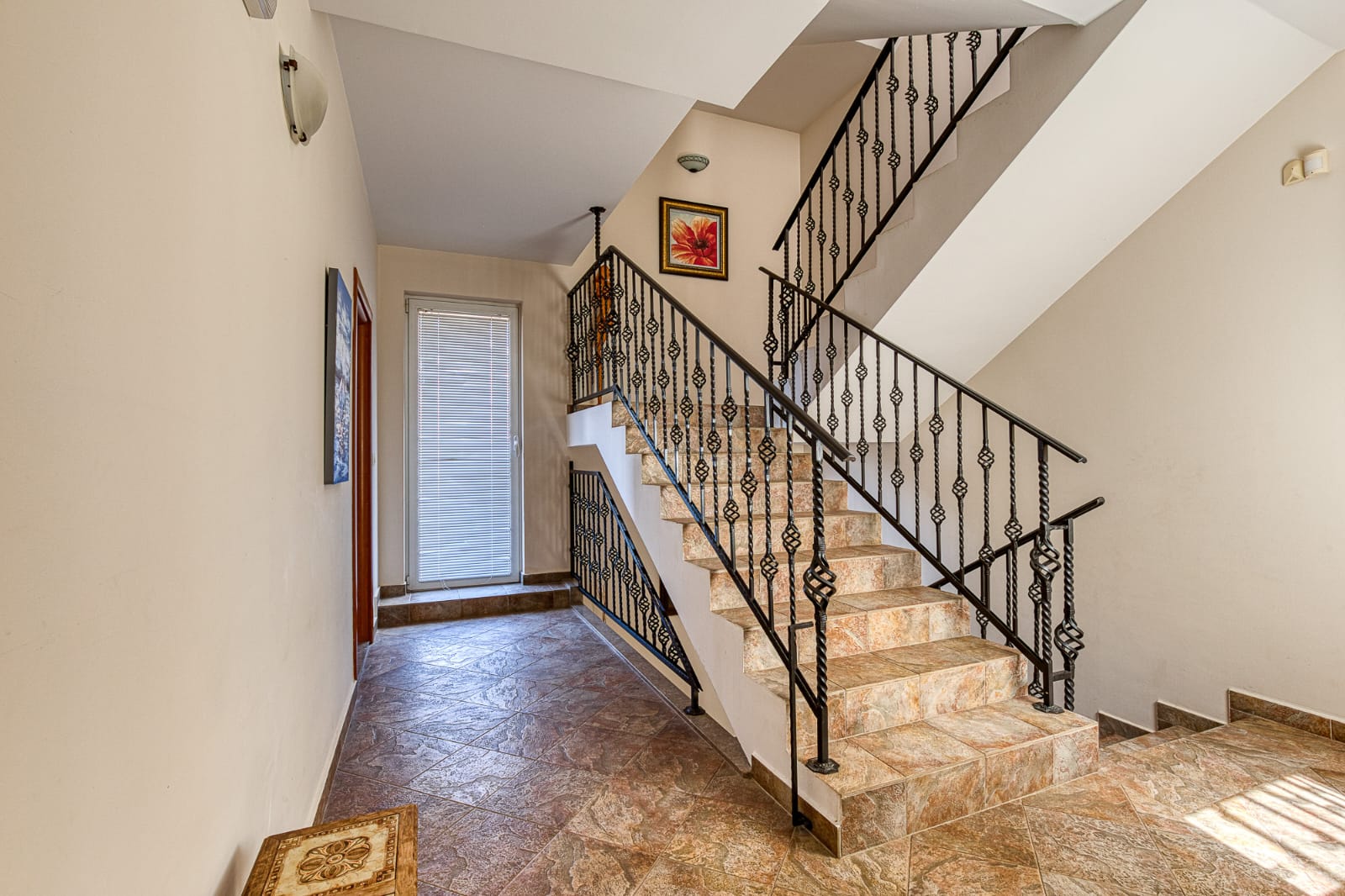 Elegant staircase with brown tiles, black railings, and stylish hallway&mdash;ideal Ulcinj investment! immobilien.ekosphere.me by ekosphere doo.