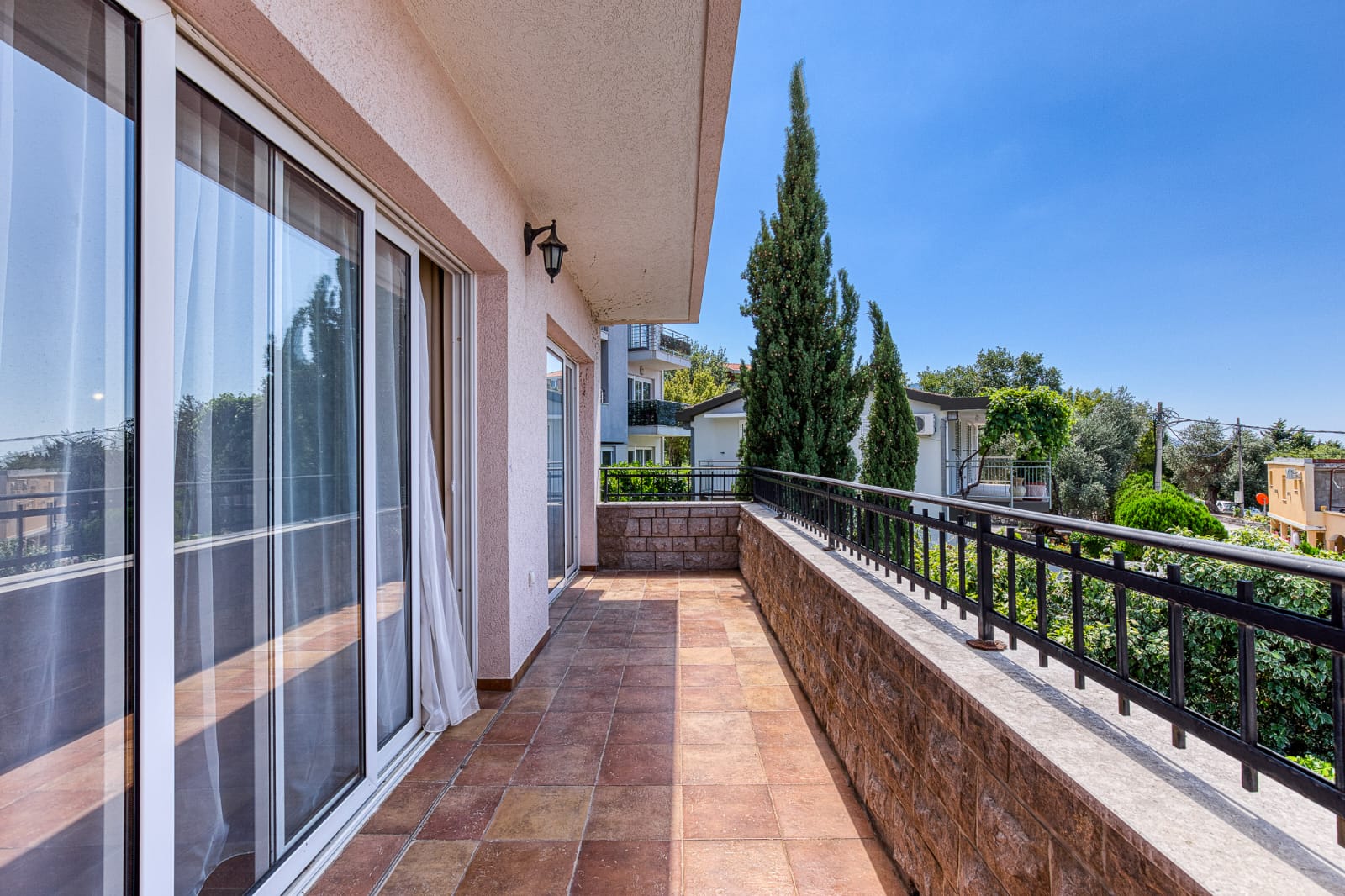 Spacious tiled balcony with metal railing, large glass doors, and scenic Ulcinj views&mdash;prime property via immobilien.ekosphere.me by ekosphere doo.