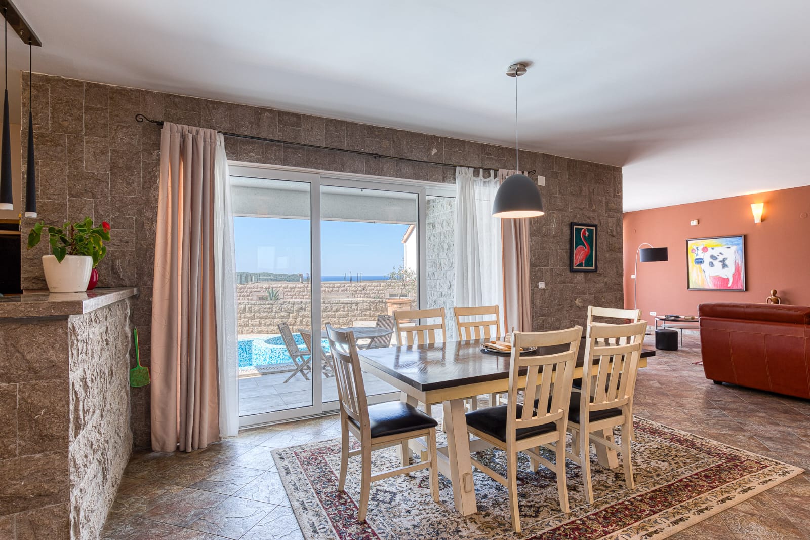 Elegant dining area with stone walls, pool views, and open-plan living&mdash;prime Ulcinj property via immobilien.ekosphere.me by ekosphere doo.