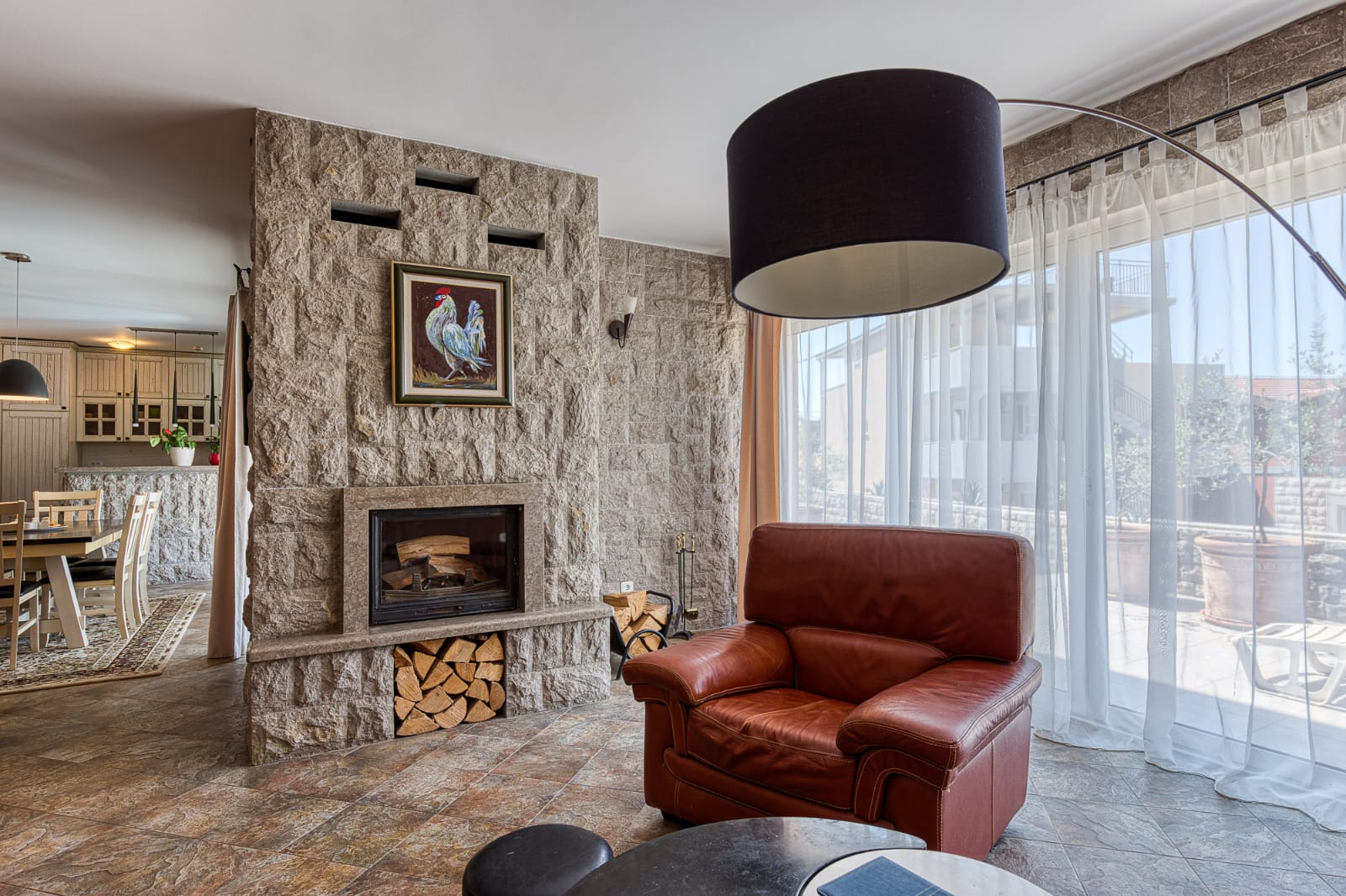 Elegant Ulcinj living room: stone fireplace, large windows, premium finishes. Exclusive on immobilien.ekosphere.me by ekosphere doo.