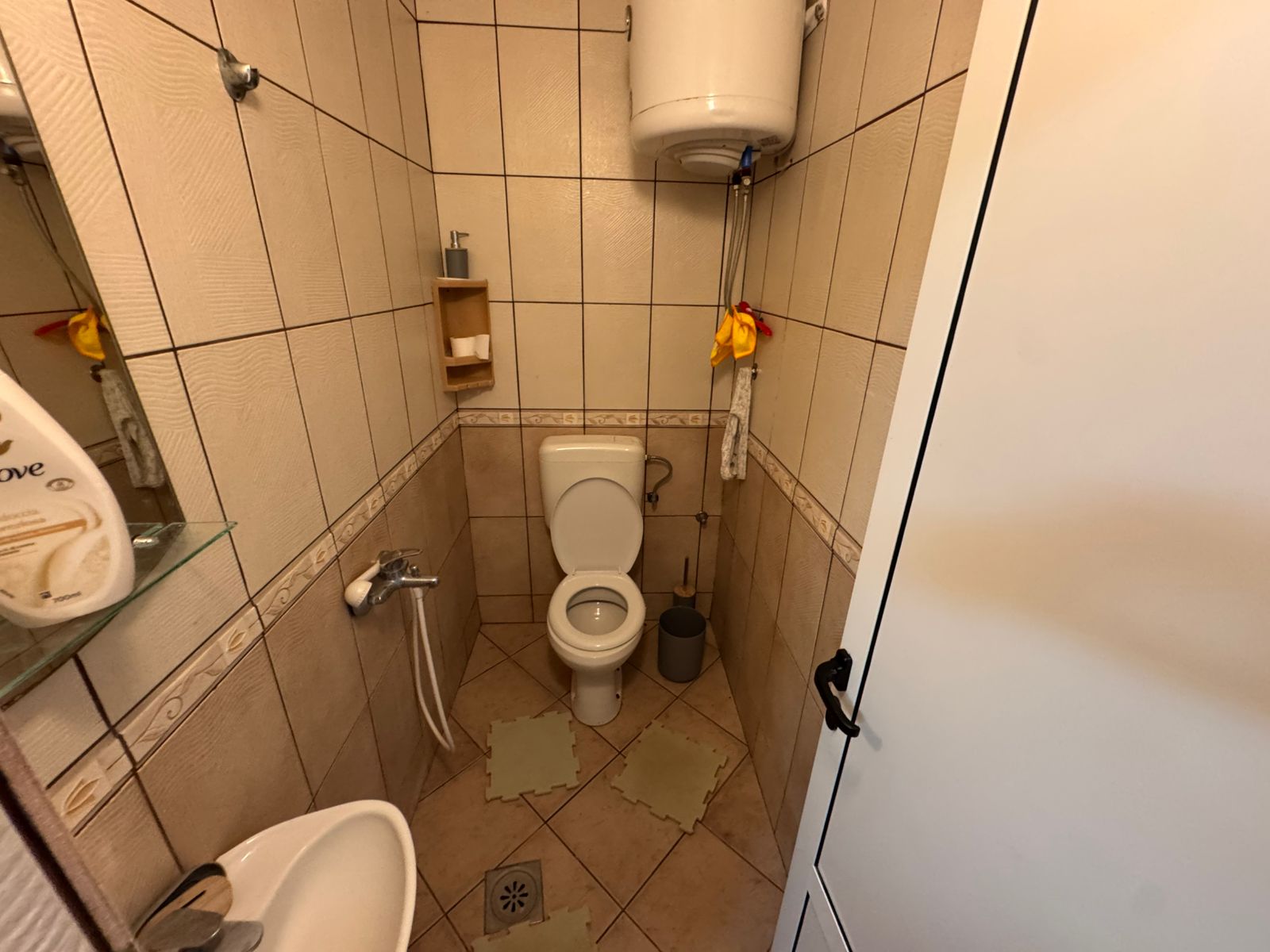 Modern tiled bathroom with toilet, sink, mirror, water heater&mdash;ideal Ulcinj Montenegro investment. Listed by ekosphere doo.