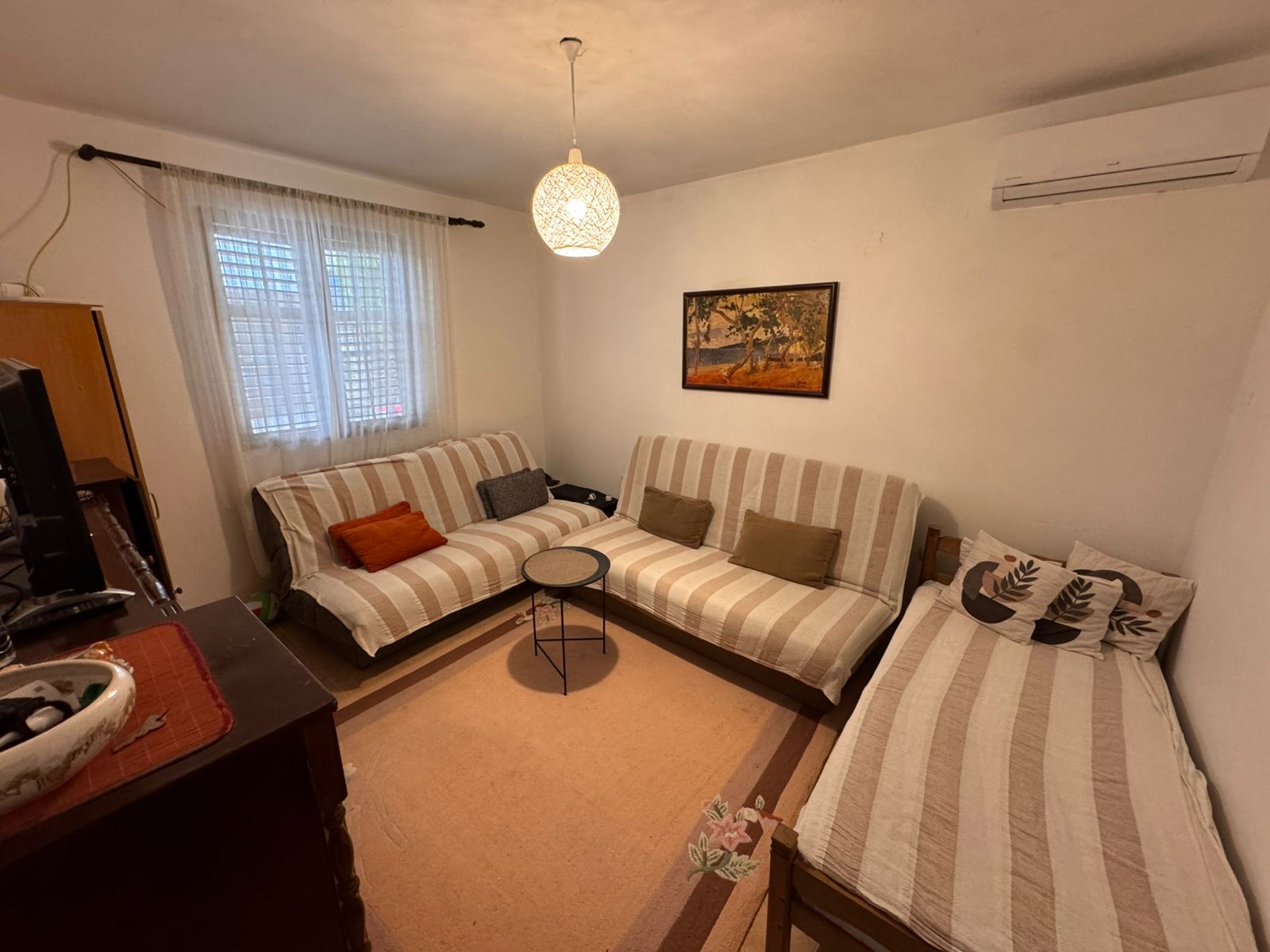 Charming Ulcinj living room: striped sofas, daybed, AC, TV, chic d&eacute;cor&mdash;invest in Montenegro at immobilien.ekosphere.me by ekosphere doo.