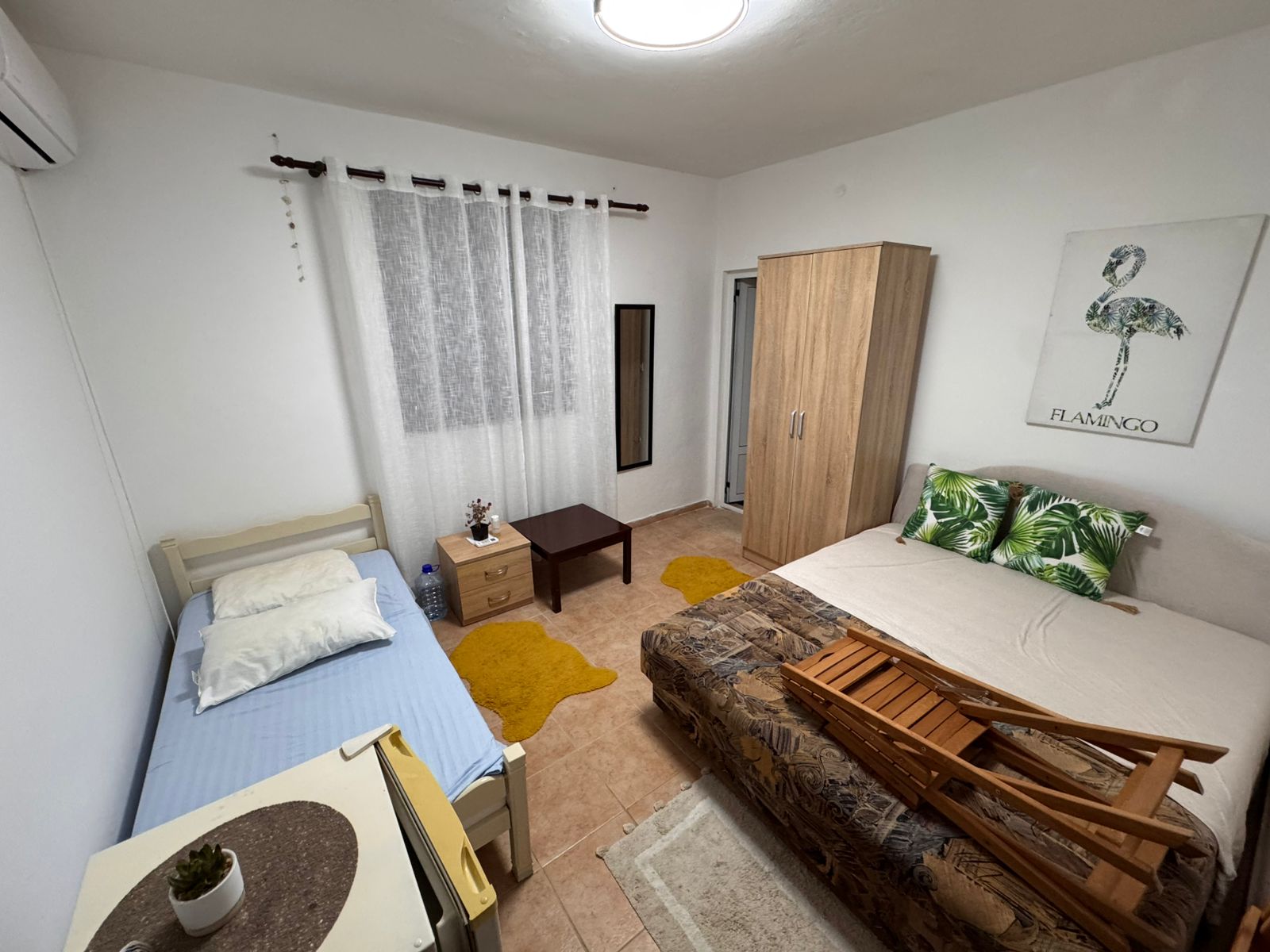 Charming Ulcinj bedroom: single & double beds, modern wardrobe, cozy rugs, stylish decor. Ideal investment on immobilien.ekosphere.me.