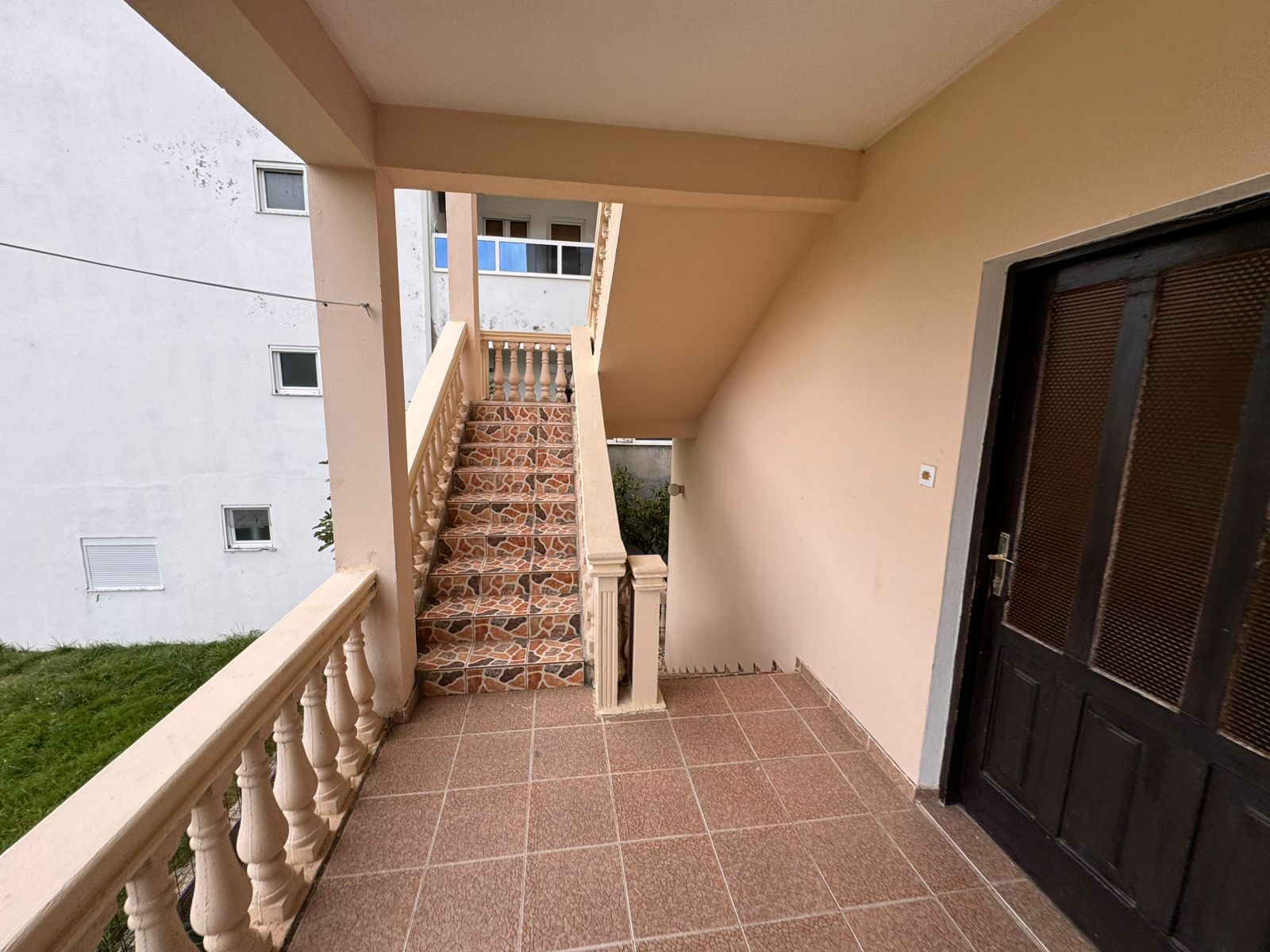 Stylish Ulcinj property: elegant tiled entry, premium wood door, designer staircase, garden views. Invest at immobilien.ekosphere.me by ekosphere doo.