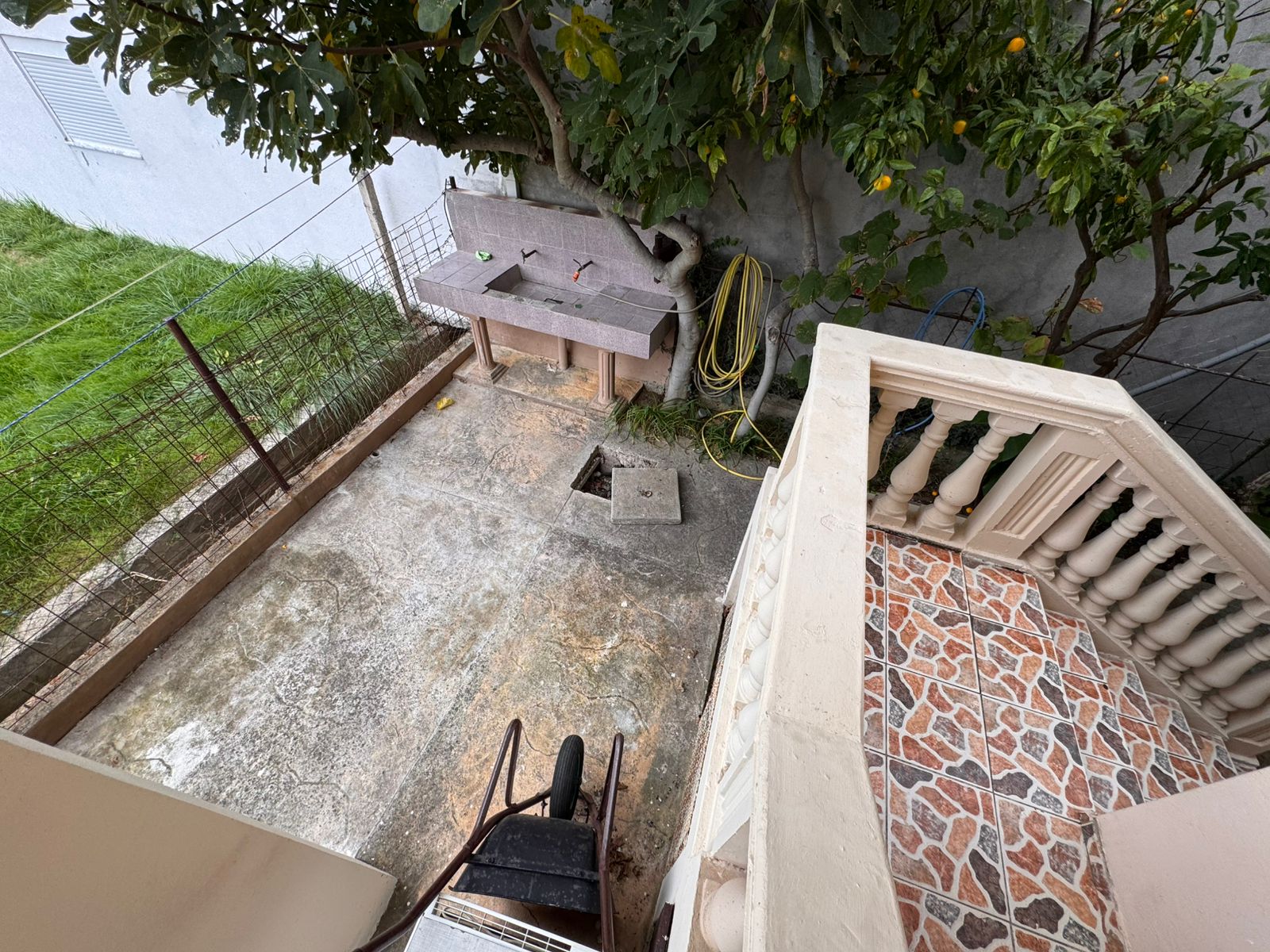 Spacious concrete backyard with tiled staircase, tree, utility sink&mdash;ideal Ulcinj investment via immobilien.ekosphere.me by ekosphere doo.
