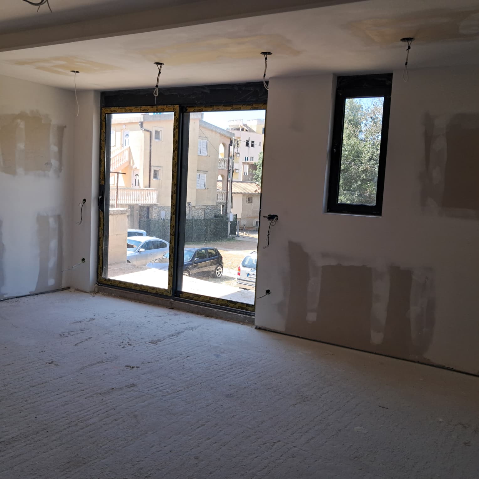 Spacious unfinished room in Ulcinj, Montenegro, ideal for investment. Large windows with street views. Exclusive at immobilien.ekosphere.me, a project of ekosphere doo.