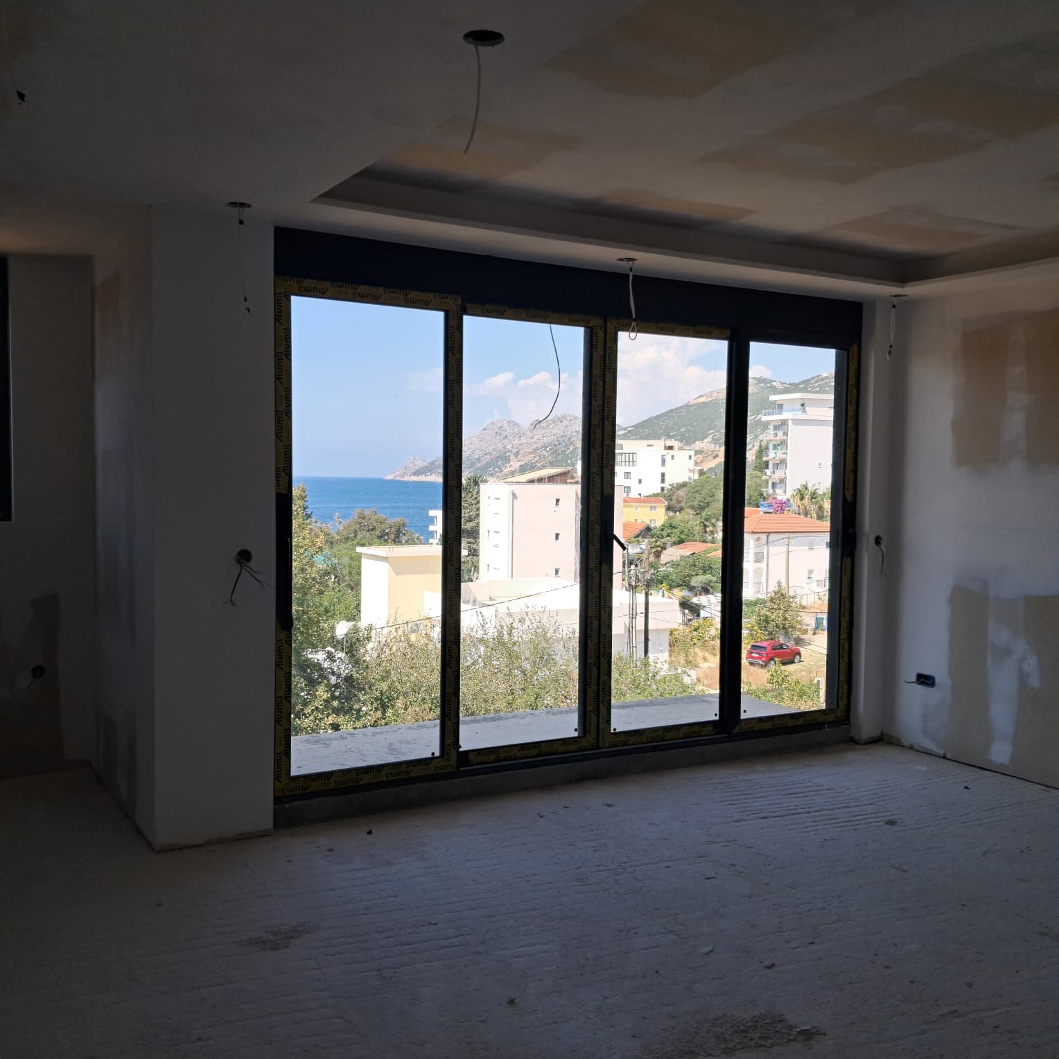 Spacious unfinished room with panoramic floor-to-ceiling windows, stunning sea and mountain views in Ulcinj. Exclusive at immobilien.ekosphere.me by ekosphere doo.