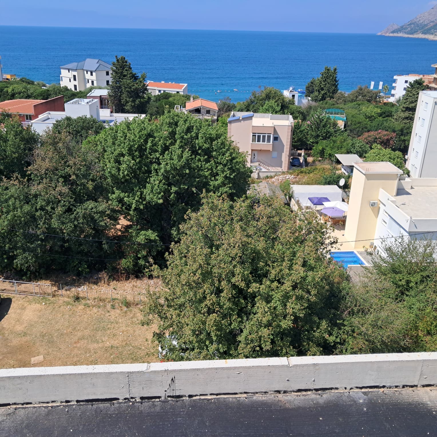Stunning aerial view of Ulcinj: coastal homes, lush trees, sea views & pool&mdash;exclusive Montenegro real estate by ekosphere doo.