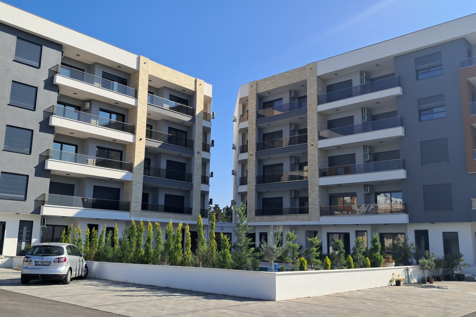 Prime Ulcinj apartments: 4-story modern buildings with balconies, large windows, landscaped gardens. Invest via immobilien.ekosphere.me by ekosphere doo.