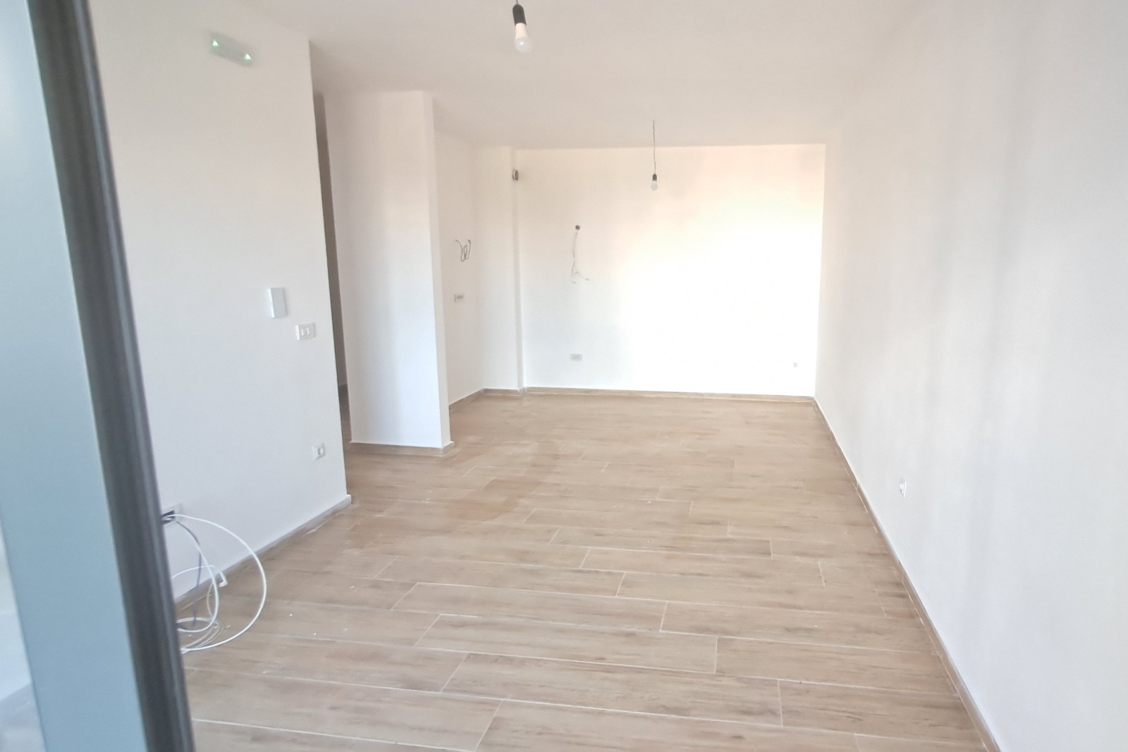 Spacious, bright room with premium light wood flooring and fresh white walls&mdash;ideal for property investment in Ulcinj, Montenegro. Powered by ekosphere doo via immobilien.ekosphere.me.