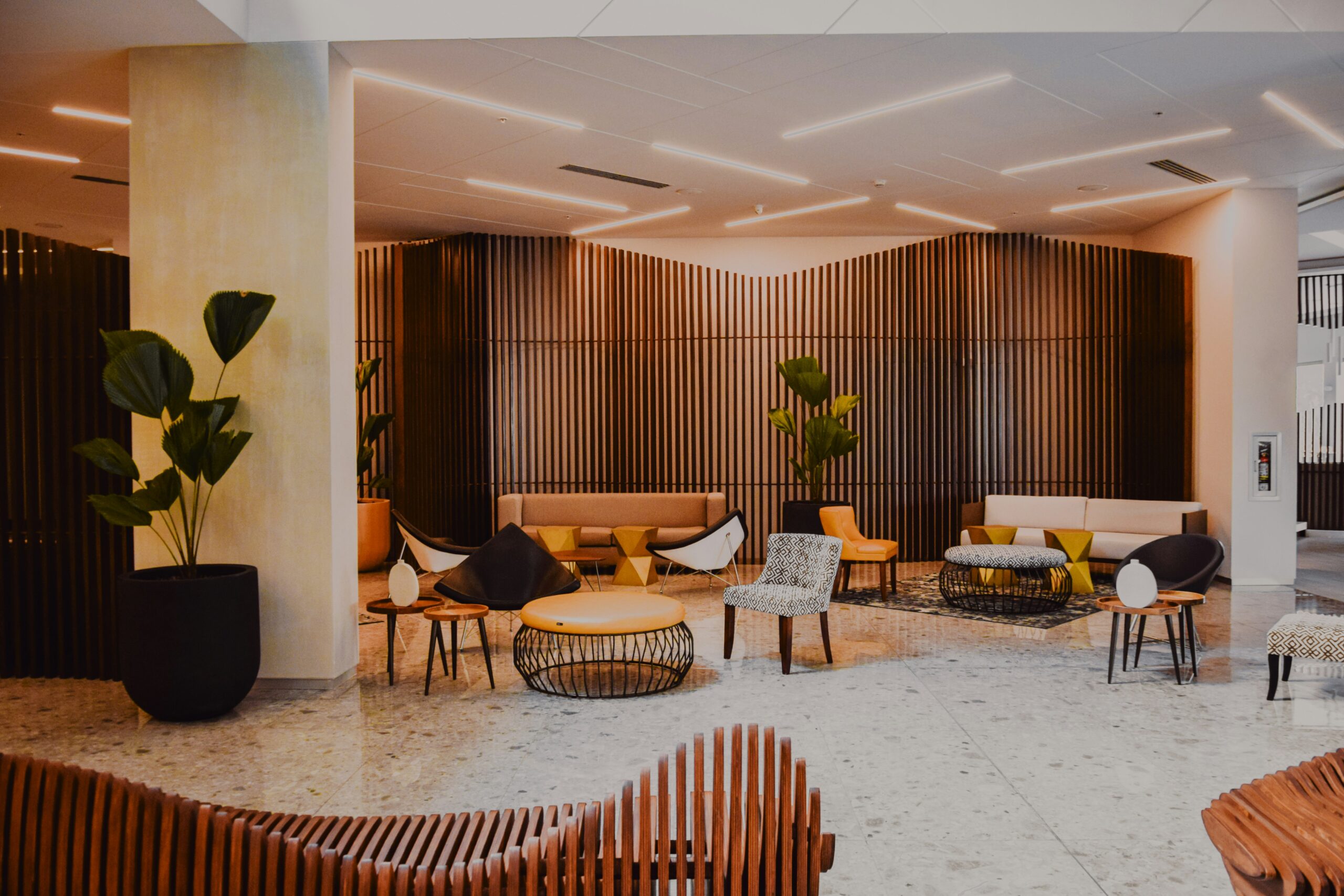 All Listings - Elegant lobby in Ulcinj with stylish sofas, terrazzo floors, wood panels&mdash;prime real estate via immobilien.ekosphere.me by ekosphere doo.